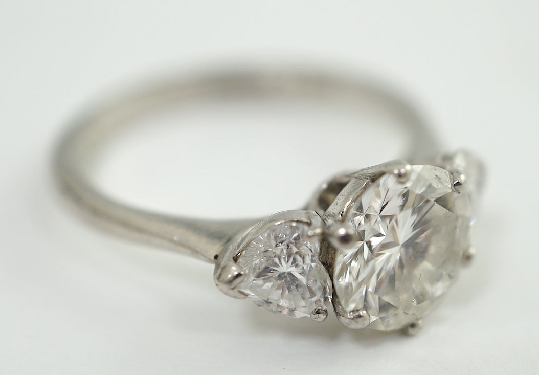 A modern Boodles & Dunthorne platinum and single stone diamond ring, with two stone heart shaped diamond set shoulders